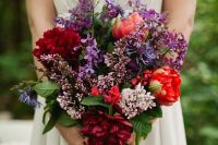 a jewel tone wedding bouquet with purple, burgundy, deep red, lilac blooms and bold ribbon is a lovely idea for the fall