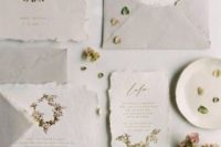 a light grey and neutral wedding invitation suite with gold calligraphy and botanical prints, with petals of handmade paper