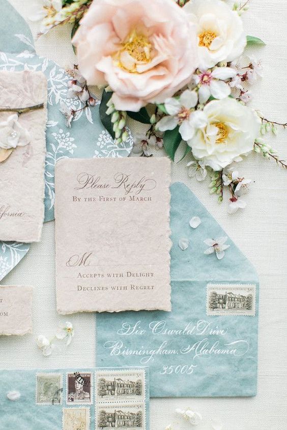 a lovely ocean blue and neutral handmade paper wedding invitation suite with a raw edge, with more modern lettering and calligraphy