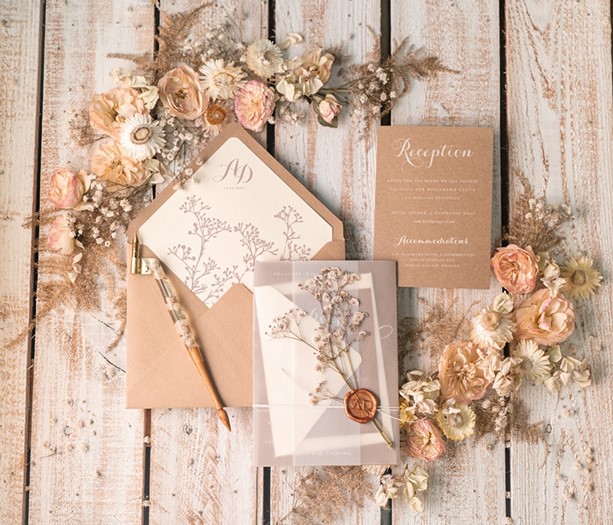 a lovely wedding invitation suite with a more modern material is paired with kraft paper and a classic wax seal