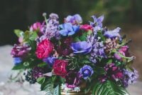 a lush floral wedding centerpiece with violet, fuchsia and burgundy flowers in a gold vase is a wow idea