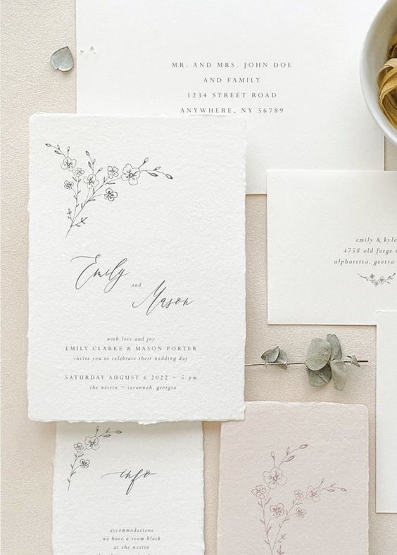 a neutral handmade paper wedding invitation suite with black calligraphy and botanical prints is a cool idea for spring