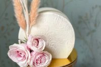 a neutral lace effect buttercream decorated with pink roses and peachy grasses is a great and chic idea for a refined vintage-inspired wedding