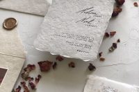 a neutral wedding invitation suite of handmade paper, torn edge and some vellum touches is a lovely idea