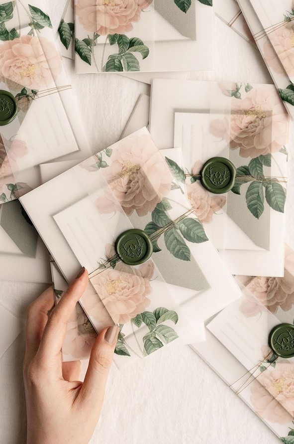 a pastel wedding invitation suite with an invite in a vellum jacket, with a green seal and some twine is a great idea for spring or summer
