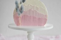 a pretty ombre pink wedding cake with textural buttercream and some lilac bunny tails for a spring or pastel summer wedding