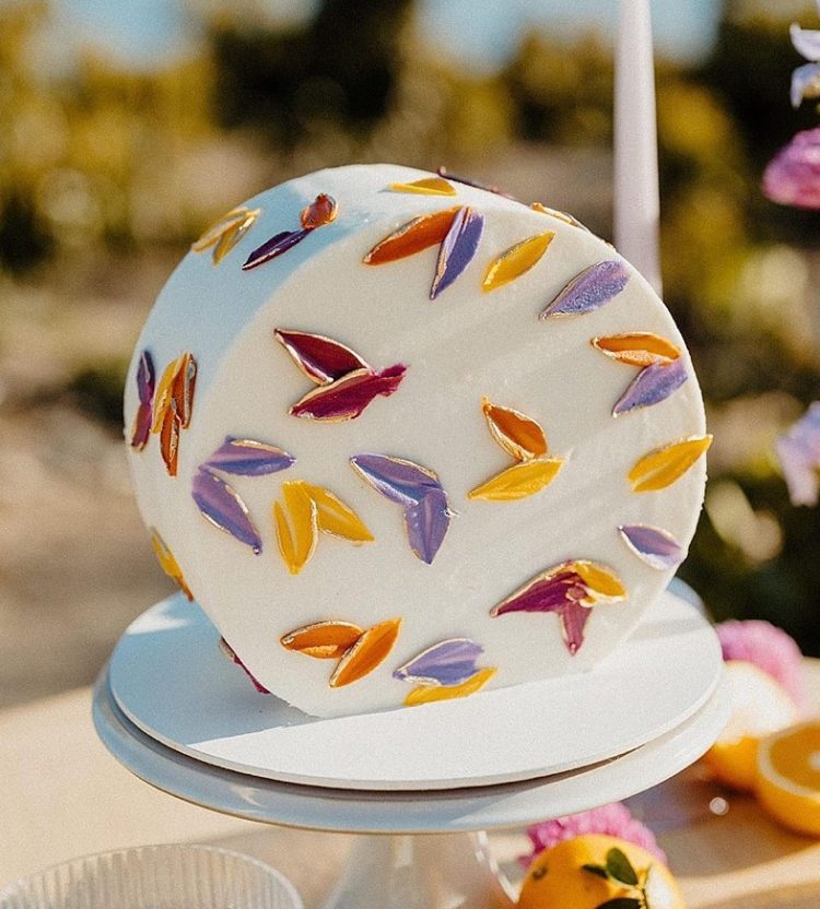 a white top forward wedding cake decorated with colorful petals is a gorgeous solution for a bright and fun summer wedding