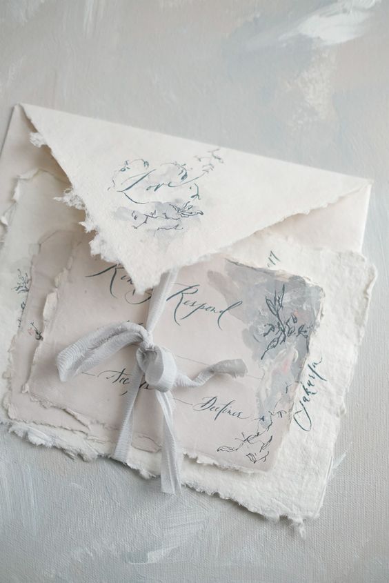 an airy and delicate neutral wedding invitation suite of handmade paper, with watercolors and some delicate painted patterns