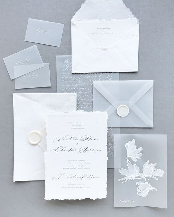 an ethereal winter wedding invitation suite with textural paper parts, a vellum envelope and vellum invites and cards with florals