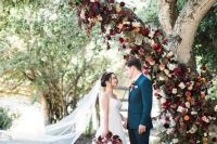 burgundy, red and orange flower tree decor to use as a wedding backdrop – living tree decor is a very trendy idea