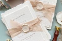 lovely neutral handmade paper wedding invitations with a raw edge, with blush ribbon and creamy seals with calligraphic letters