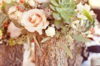 08 a rustic wedding centerpiece of a tree stump, blush and neutral blooms and greenery and large succulents is a cool idea for a rustic wedding