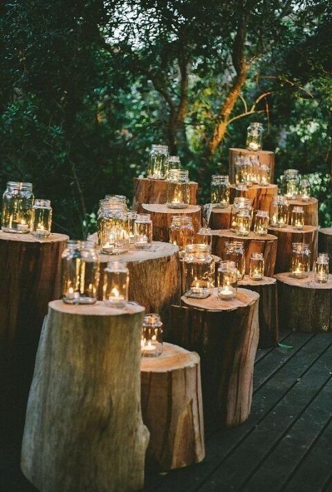 a beautiful rustic wedding altar composed of tree stumps and jars with little tealights is a gorgeous idea you can repeat yourself