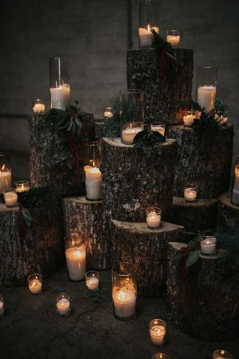 a woodland wedding altar of tree stumps, candles and greenery is a beautiful idea for a woodland or rustic wedding