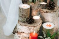 18 a fabulous Christmas wedding decoration made of tree stumps and branches, pinecones, red and white candles, berries and greenery, some red blooms