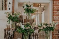 22 a pretty rustic wedding decoration made of tree stumps with wildflower and greenery arrangements and candles is a lovely idea