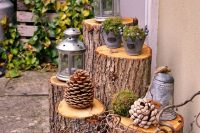 23 a pretty rustic wedding decoration made of tree stumps, twigs, oversized pinecones, lanterns and buckets plus bells is cool for a woodland wedding