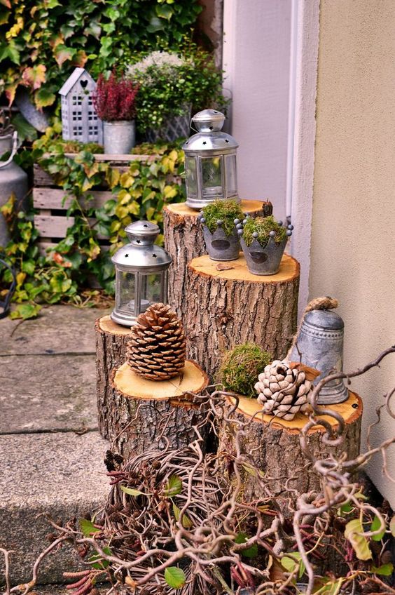 a pretty rustic wedding decoration made of tree stumps, twigs, oversized pinecones, lanterns and buckets plus bells is cool for a woodland wedding