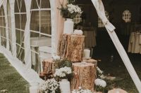 29 a rustic wedding decoration of tree stumps, mini pumpkins, candles and white bloom arrangements is a cool idea for a wedding