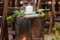 39 fall aisle decor with a tree stump, with large candleholders, green and dark foliage is a pretty rustic idea, you can DIY such an aisle easily