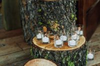 40 forest or rustic wedding decor done with tree stumps with moss and small candles in glasses is a cool rustic idea