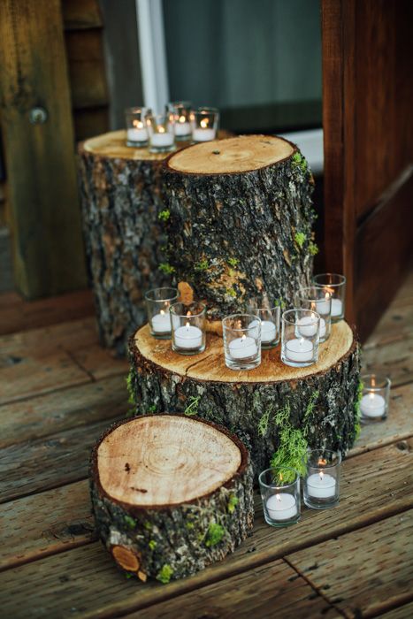 forest or rustic wedding decor done with tree stumps with moss and small candles in glasses is a cool rustic idea