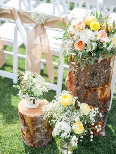 pretty rustic wedding aisle decor done with tree stumps, white, yellow and blush blooms in jars and a cup is a great idea for a rustic wedding