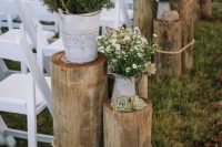 43 rustic wedding aisle decor with tree stumps secured with rope, succulents, greenery in buckets, vintage jugs with wildflowers