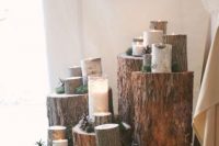 44 rustic wedding decor composed of tree stumps with moss, pinecones and candles plus greenery is a great idea for a rustic or woodland wedding