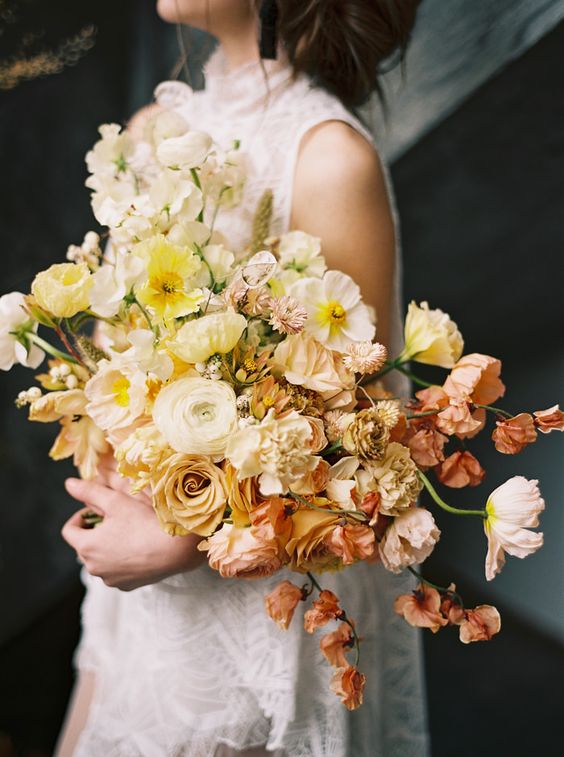 a beautiful ombre wedding bouquet from white to yellow, coffee colored and dusty pink blooms including roses and poppies