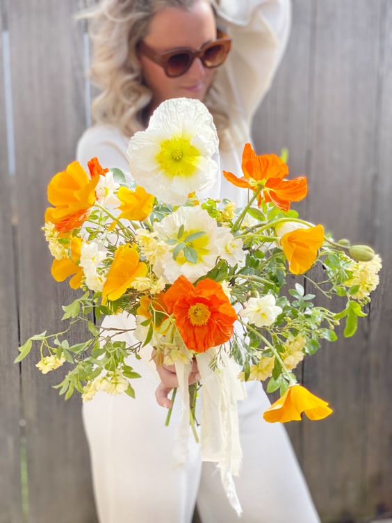 a bright wedding bouquet of yellow, red and white poppies and greenery is a cool idea for spring or summer