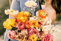 a colorful wedding bouquet of bold yellow and light pink poppies, pink and coffee-colored roses, pink and orange ranuculus and some fillers