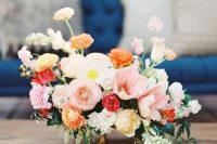 a muted color wedding centerpiece of white annd blush poppies, orange and yellow blooms and greenery is amazing for spring or summer