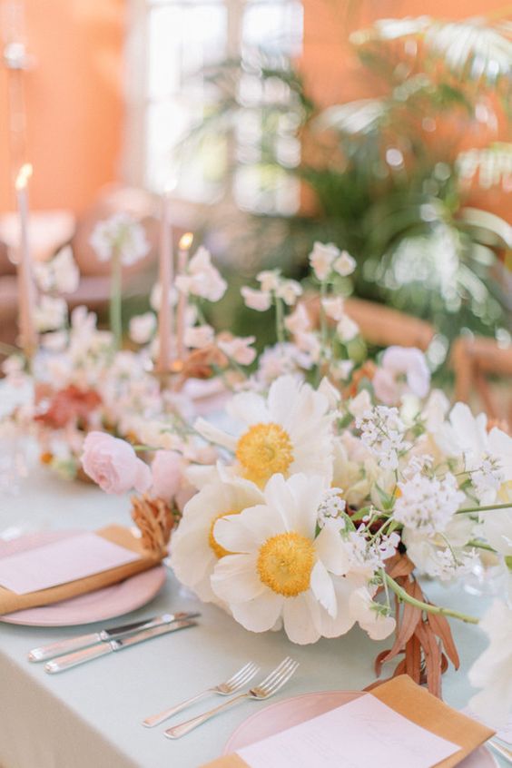a neutral wedding centerpiece of white poppies, pink ranunculus and some fillers is a gorgeous spring wedding centerpiece