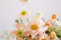 a pastel wedding centerpiece of blush poppies, white blooms and some greenery is a beautiful idea for a spring wedding