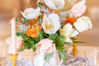 a pastel wedding centerpiece of white, blush and orange poppies and greenery is a great idea for a rustic wedding