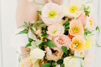 a sophisticated pastel wedding bouquet of light pink roses, light pink and yellow poppies and cascading greenery for a spring birde