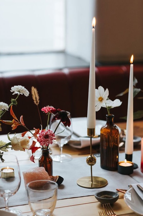 apothecary bottles with various flowers and dried elements, agates and tall candles for a refined wedding tablescape