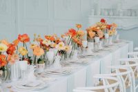bright cluster wedding centerpieces with red ad yellow poppies in white vases look super cool and very modern