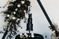 03 a black triangle wedding arch decorated with neutral and deep purple blooms, pampas grass, greenery and dark foliage is a gorgeous idea for Halloween