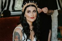 05 a rock bridal look with a lace fitting V-neckline wedding dress, a gorgeous crystal tiara and a bold makeup plus tattoos
