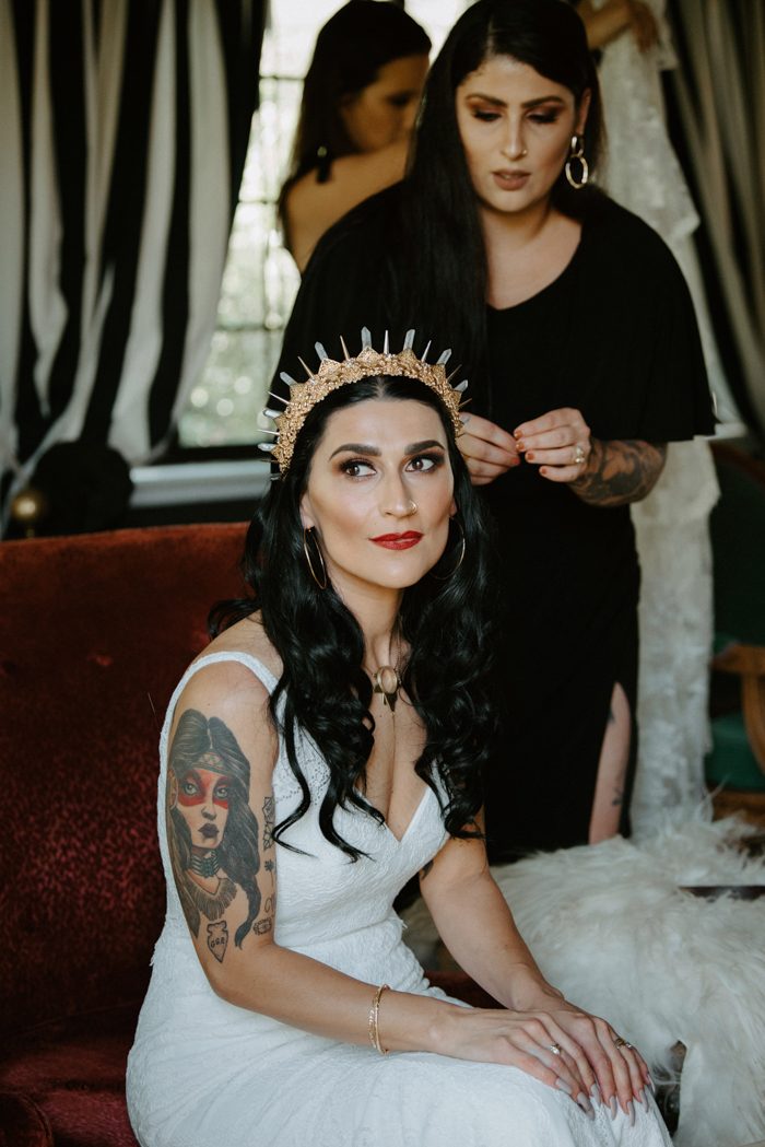 a rock bridal look with a lace fitting V-neckline wedding dress, a gorgeous crystal tiara and a bold makeup plus tattoos