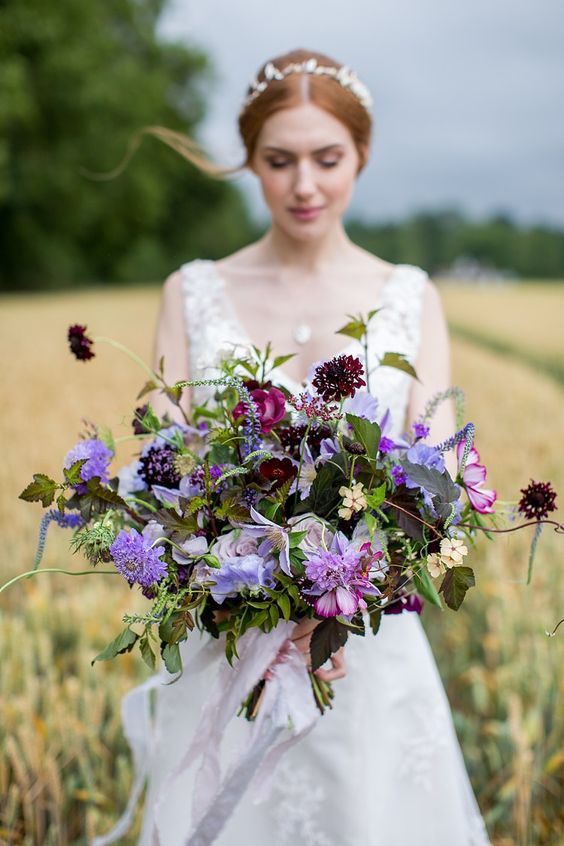 a bold and catchy wedding bouquet with deep burgundy, lilac and pale lilac blooms and greenery is amazing for fall or summer