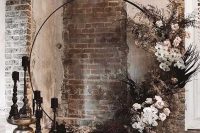 08 a fantastic round wedding arch decorated with neutral and blush blooms, dark leaves and foliage, black candles in candleholders for a Halloween wedding