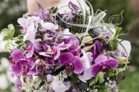 09 a breathtaking wedding bouquet with purple and neutral orchids, greenery, berries, feathers and air plants is a bold solution