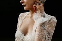 09 a gorgeous rock n roll bridal look with a romantic lace wedding dress with a deep sweetheart neckline, a statement pearl headpiece, tattoos, statement jewelry and a black lip