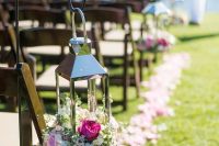 10 a pretty pink wedding aisle with pink petals on the ground, a polished lantern filled with neutral and pink blooms