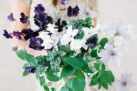 11 a catchy and contrasting wedding bouquet with deep purple and white blooms and various types of greenery cascading is amazing