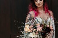 a statement rock n roll bridal look with a romantic boho lace applique wedding dress, ombre hair from black to hot pink, a contrasting bouquet with deep purple blooms