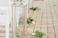 13 a simple and lovely wedding aisle decorated with super tall lanterns with blooms and greenery around is a great idea